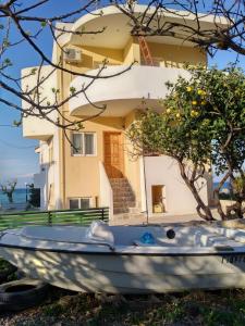 a small boat in front of a house at SereneLands Seaside House by MPS in Liyiá