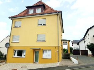 a yellow house with a red roof at Apartment Bad Salzschlirf in Bad Salzschlirf