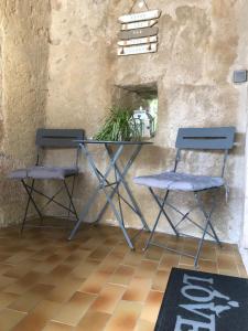 two chairs and a table in front of a wall at Chambre d'hôte Lavande - Le soleil des Cévennes in Saint-Jean-du-Gard +29 photos