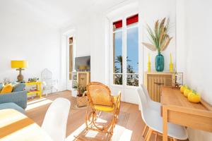 a living room with a table and chairs at REGINA - Somptueux 3 pièces - carré d'or Menton - vue mer in Menton