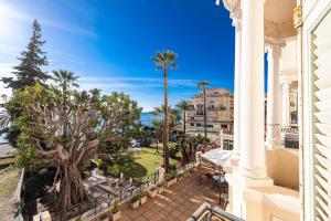 a balcony with a view of the ocean and palm trees at REGINA - Somptueux 3 pièces - carré d'or Menton - vue mer in Menton