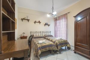 sypialnia z 2 łóżkami i drewnianym biurkiem w obiekcie Gmg - Mondello House w mieście Palermo