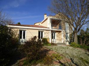 a white house with a tree in front of it at Villa les muriers in Manosque