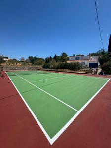 a tennis court with a tennis racket on it at Quinta da Felicidade, Casa Estrela in Guia