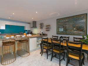 een keuken met een houten tafel en een aantal stoelen bij Wingspan in St Ives