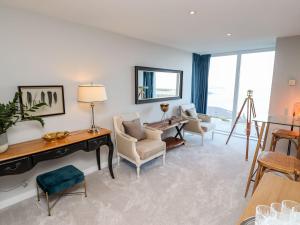 een woonkamer met een tafel en stoelen en een bureau bij Wingspan in St Ives