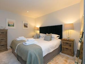 een slaapkamer met een groot bed en twee nachtkastjes bij Wingspan in St Ives