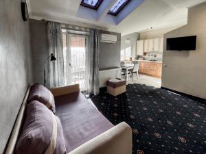 a living room with a couch and a tv and a kitchen at Apartments On Zaliznychna 49 in Ivano-Frankivsʼk