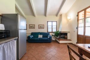 a kitchen and living room with a blue couch at Villa La Stalla Il Sole Verde in Bucine