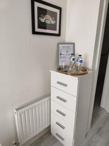 a white dresser with glasses on top of it at Cozy Room in Dublin +5 photos