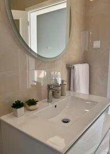 a bathroom with a white sink and a mirror at Calheta Nest in Calheta +25 photos