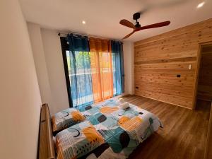 a bedroom with a bed in front of a window at Écrin du lac in Cilaos