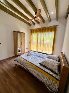 a bedroom with a large bed with a ceiling fan at Écrin du lac in Cilaos