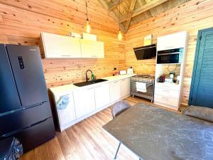 a kitchen with a refrigerator and a table in a cabin at Écrin du lac in Cilaos