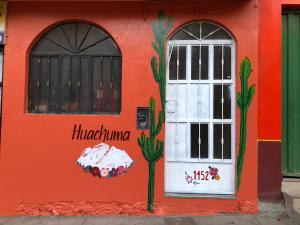 a building with a door and cactus painted on it at Huachuma Rooms in Huaraz