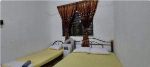 two beds in a room with a window at KK Minimalist Budget 2 Bedroom Appt f 6 free park in Penampang