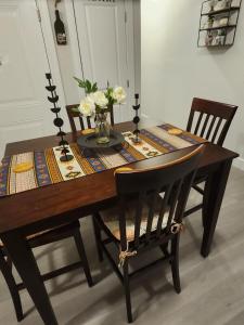 Una mesa de comedor con un jarrón de flores encima. en Comfy, cozy, affordable and private - free parking, en Richmond Valley
