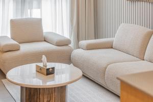 a living room with a couch and a coffee table at 1BR Wow Apartment in Sharjah - Crystal Retreat in Sharjah Intl