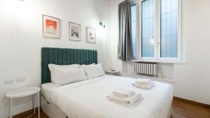 sypialnia z białym łóżkiem i ręcznikami na nim w obiekcie Italianway - Porta Ticinese 67 w Mediolanie