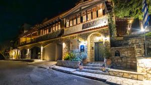 an old stone building with a green door at night at Fanaras Hotel in Kalavrita +54 photos