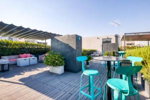 un patio con taburetes azules, mesa y sillas en AR 218 Hotel by ULIV, en Ciudad de México 15 fotos más
