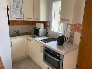 a small kitchen with a stove and a microwave at chambre d hôtes ALSABREIZH in Lanvollon