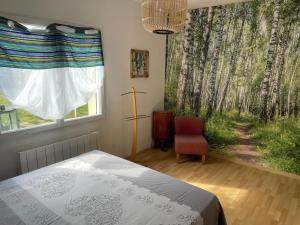 a bedroom with a bed and a window with trees at chambre d hôtes ALSABREIZH in Lanvollon