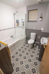 Un baño con bañera, inodoro y lavabo. en 7 Morelli Plaza, en Portstewart
