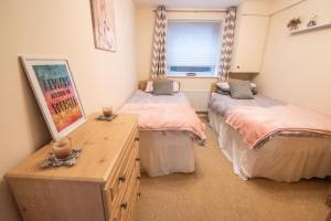 1 dormitorio con 2 camas, vestidor y ventana en 7 Morelli Plaza, en Portstewart
