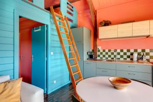 a kitchen with blue and orange walls and a ladder at Quinta da Estrela in Ponte Nova