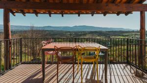 a table and chairs on a deck with a view at Quinta da Estrela in Ponte Nova +24 photos