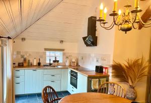a kitchen with blue cabinets and a table and a chandelier at Westgaerde20 in Dwingeloo
