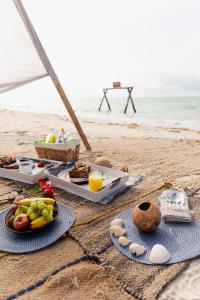 a table with plates of food on the beach at Totem Beach Club - Celestun in Celestún
