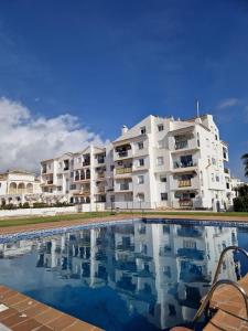 a large white apartment building with a swimming pool at Beautiful apartment in Calahonda beach in Sitio de Calahonda