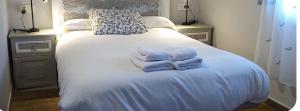 a bed with three folded towels on top of it at El Desván del Chisco in Cudillero