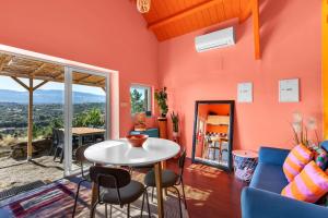 a living room with orange walls and a table and chairs at Quinta da Estrela in Ponte Nova