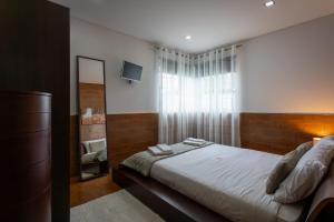 Un dormitorio con una cama con espejo y una ventana. en Bandeira'S house, en Antuã 46 fotos más
