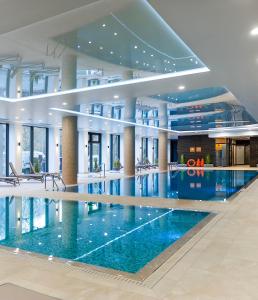 a large swimming pool in a building at FARO Apartamenty Nadmorskie Tarasy SPA przy Latarni i Molo Baseny w cenie Pools inklusive in Kołobrzeg