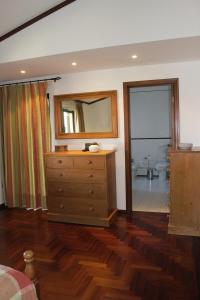 a bedroom with a dresser and a mirror and a bathroom at R3 - Miravillas - Rosas 33 in Mira