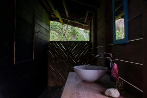 a bathroom with a bowl sink on a wooden counter at Casa Cielito in Nuquí