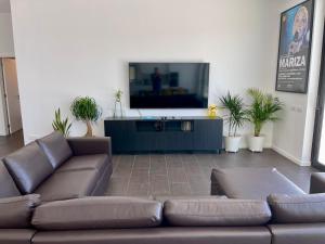 ein Wohnzimmer mit Couch und Flachbildfernseher in der Unterkunft Casa Iroko - a modern villa, with private pool, in a quiet area in Nadadouro