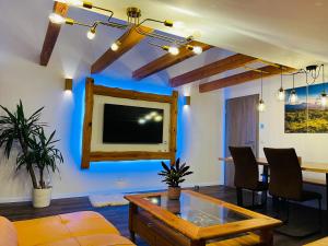 a living room with a tv and a table at Landhaus „Divija Haus“ Ferienwohnung in Pfronten