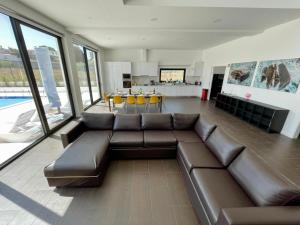 ein Wohnzimmer mit einem braunen Sofa und einem Tisch in der Unterkunft Casa Iroko - a modern villa, with private pool, in a quiet area in Nadadouro