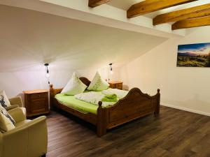 a bedroom with a green bed and a chair at Landhaus „Divija Haus“ Ferienwohnung in Pfronten