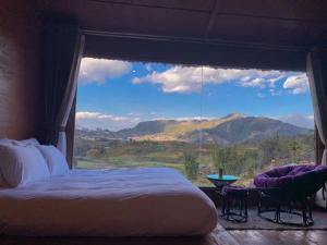 a bedroom with a bed and a large window with a view at Rose Farm Sa Pa in Sapa