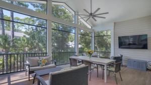 a screened in porch with a table and chairs at Luxury Family Home with Pool and Spa, Screened Porch, Close to Beach in Hilton Head Island