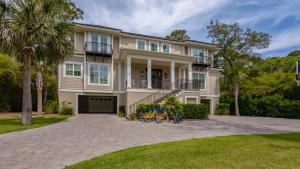 a large house with bikes parked in the driveway at Luxury Family Home with Pool and Spa, Screened Porch, Close to Beach in Hilton Head Island
