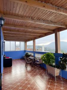a balcony with a table and chairs and windows at Casa Abdou in Chefchaouen
