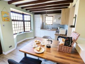 a kitchen with a wooden table with two dishes on it at King's Cottage in Bedale +14 photos