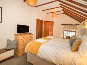 a bedroom with a large bed and a television at King's Cottage in Bedale